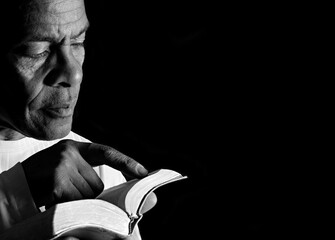 praying to god with hands together Caribbean man praying with black background with people stock photo stock image