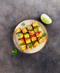 Paneer Tikka - marinated Indian fried paneer cheese with capsicum on dark background. Indian food. 