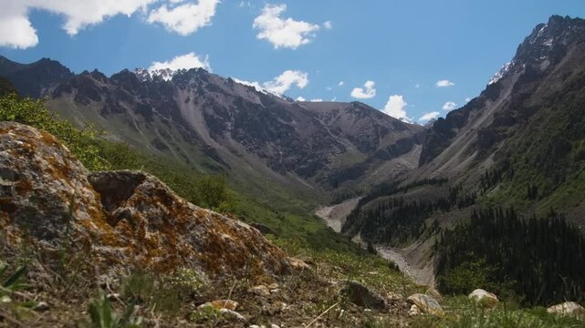 This footage showcases the dramatic landscape of Ala Archa National Park, Kyrgyzstan, under cloudy skies, capturing its rugged mountains and valleys.