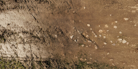 view from above on surface of texture of dry road with tractor tire tracks in countryside