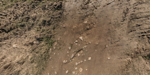 view from above on surface of texture of dry road with tractor tire tracks in countryside