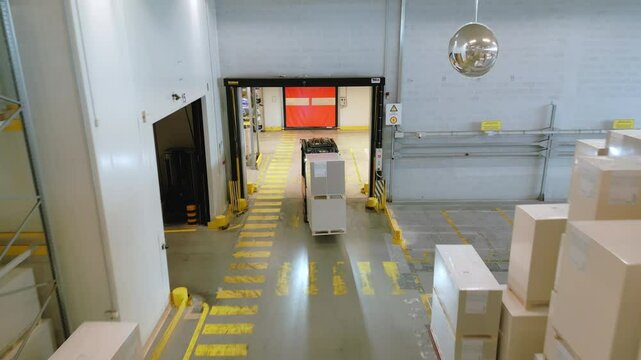 A panoramic warehouse view reveals aisles, boxes, and a loading dock, highlighting efficient storage and distribution logistics.