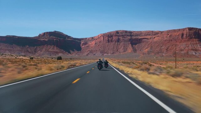 Experience breathtaking views as fearless motorcyclists navigate Arizonas winding roads alongside Utahs Monument Valley, known for its stunning natural scenery that captivates all riders