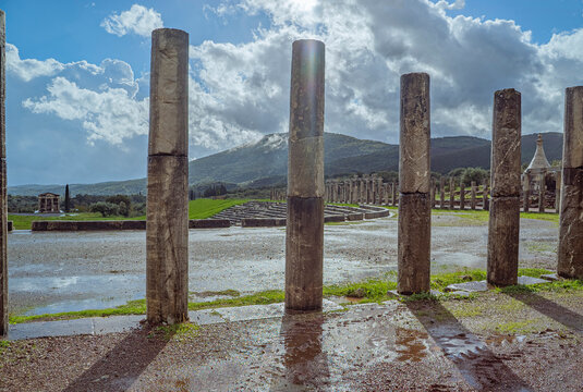 Archaeological site of Ancient Messene, UNESCO World Heritage, Peloponnese, Greece, Ancient columns stand in a wet landscape under clouds