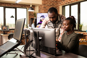 Serious african american colleagues analyzing a startup project on a desktop monitor in a startup...