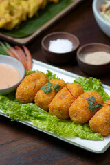 Delicious Crispy Croquettes with Dipping Sauce on a Leafy Garnish