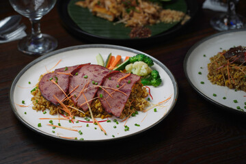 Grilled Sliced Beef over Fried Rice with Steamed Vegetables and Fresh Garnishes