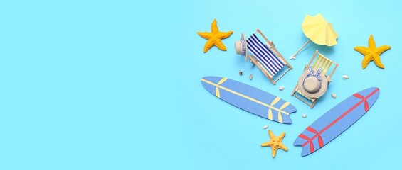 Mini surfboards with deck chairs, starfishes and seashells on blue background with space for text