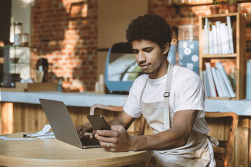 Online ordering, new normal and modern cafe during covid-19. Millennial african american guy...