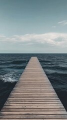 Fototapeta premium Tranquil wooden pier extending into a vast ocean.