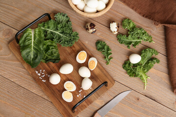 Board with fresh boiled quail eggs and lettuce on wooden background