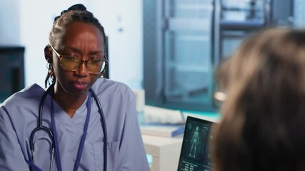 African american nurse and patients couple engage in routine checkup with healthcare records and x ray results files to find right treatment for wellness and recovery. Healthcare industry. Camera B.