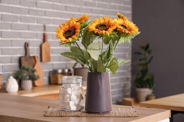 Vase with sunflowers on counter in kitchen