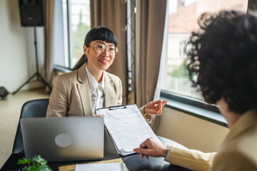 Japanese business woman give contract for signature to client