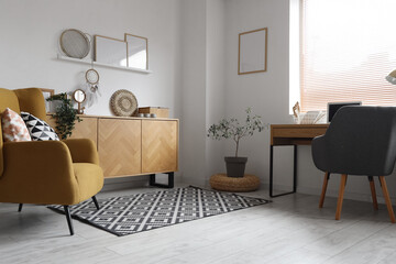 Interior of living room with workplace, commode and armchair