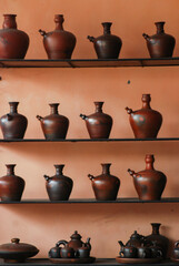 Pottery, pots, jugs displayed on shelves, interior decoration, selective soft focus. Many...