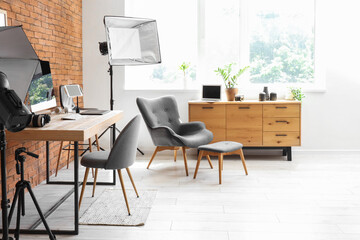 Photographer workplace with computer, photo cameras and lighting equipment in modern studio