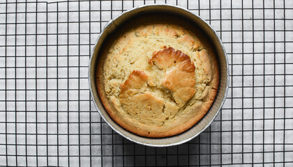 Overhead view of homemade cake on a cooling rack, top view of fresh cake cooling on countertop