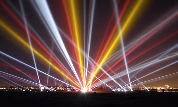 Colorful light beams radiating from a field at night.