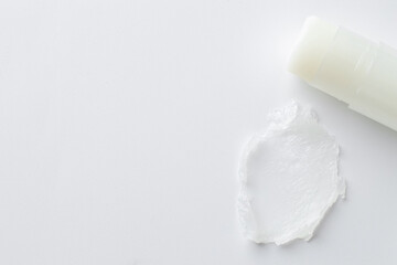 Stick of lip balm and sample on white background, top view. Space for text