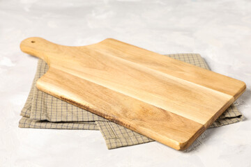 Empty cutting board with napkin on white grunge table, closeup