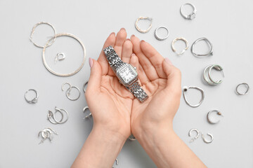 Female hands with beautiful silver jewelry on light background