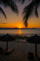 The sun rises from the hills at Dadonghai beach, Sanya, China