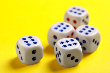 Dices with red and blue pips on yellow background, closeup