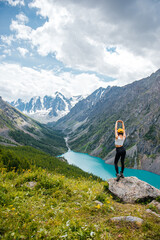 A girl on the shore of Lake Shavlinsky in the Altai Mountains, Siberia, Russia