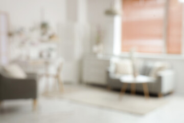 Blurred view of light office with workplace, pegboard and sofa
