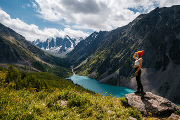 A girl on the shore of Lake Shavlinsky in the Altai Mountains, Siberia, Russia