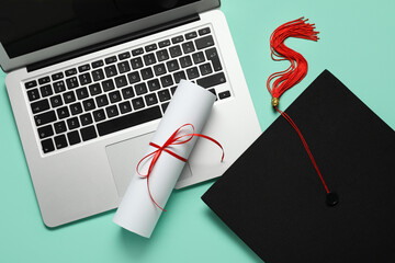 Graduation hat, laptop and diploma on turquoise background, top view. Online education concept