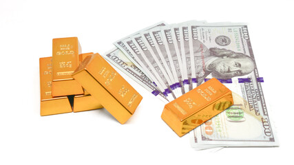 shiny gold bullion on top of stack of US dollar banknotes isolated on white background. gold...