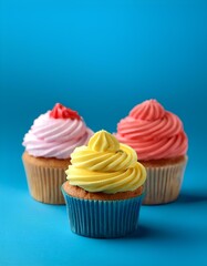 colorful cupcakes on blue background with copy space