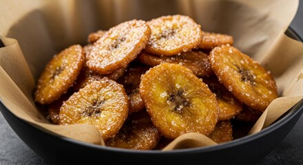 Delicious homemade caramelized banana chips with sparkling sugar in bowl