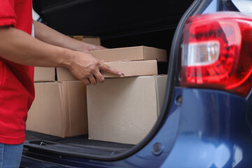 Professional Delivery Man Loading Packages Into Car Trunk, Express Delivery Service