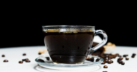 Steaming black coffee in glass cup resting on white surface, surrounded by scattered coffee beans and crisp cookies, evoking warm morning comfort