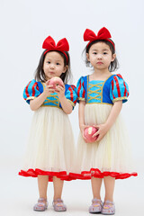 Playful cute twin little girls on white background