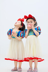 Playful cute twin little girls on white background
