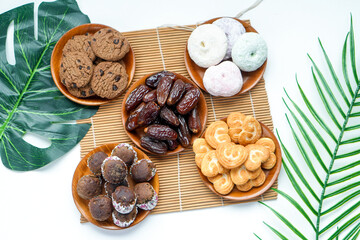 Top View Of Various Cookies, Snacks, Donuts, Cakes And Dates Fruit On White Background