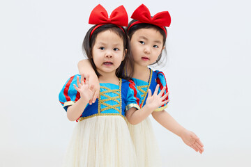 Playful cute twin little girls on white background