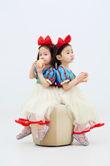 Playful cute twin little girls on white background