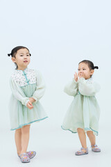 Playful cute twin little girls on white background