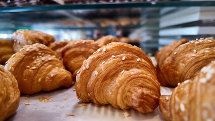Freshly baked croissants displayed in a bakery case