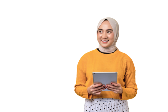 Beautiful smiling happy Asian girl wearing hijab holding digital tablet and looking aside at copy space isolated on transparent background