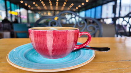 Colorful coffee cup on a table in a lively cafe setting
