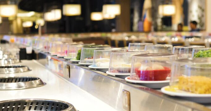 Conveyor belt transporting colorful sushi plates through sleek modern restaurant, presenting diverse japanese culinary options for diners