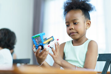 Fototapeta premium Group of diverse children enjoy learning about the STEM.