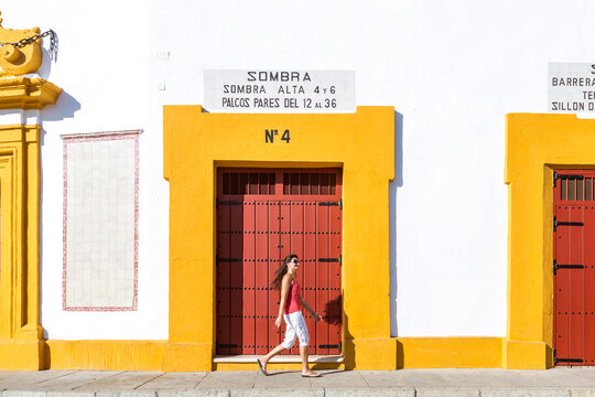 Woman walking in front of Plaza de Toros, Seville, Spain