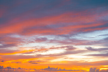 Beautiful sunset with dramatic orange sky and twilight clouds glowing in golden and red hues.